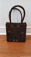 Front view of the beaded handbag showing overall shape and floral bead design
