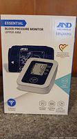 Front view of the Essential A&D Medical blood pressure monitor box showing the product image and branding, specifying it is an upper arm monitor.