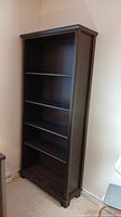 Full front view of the tall espresso finish bookshelf showing 5 shelves with mostly dark smooth wood grain.