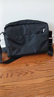 Black nylon briefcase front view with zipper and shoulder strap.