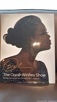 Front cover of the coffee table book showing Oprah Winfrey's profile with title and signature.