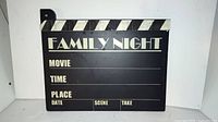 Front view of the wooden family night movie clapperboard sign showing text and writable sections.