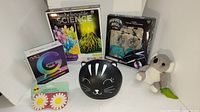 Photo showing the lot including science kits, hover ball toy, helmet, plush koala, and sunglasses.