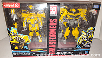 Front view of the two Bumblebee Transformers figures in unopened original packaging with Target exclusive sticker and Hasbro and Takara Tomy logos visible. Figures bright yellow and detailed, packaging good with slight damage on top.