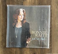 Sealed vinyl album cover showing Bonnie Raitt's portrait and album title on wooden surface.