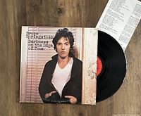 Vinyl LP titled 'Darkness on the Edge of Town' by Bruce Springsteen with album cover, record partially pulled out, and lyric insert included in photo.