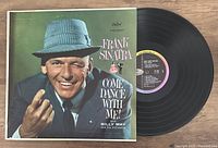 Photo showing the front album cover featuring Frank Sinatra in a suit and hat, alongside the vinyl record partly out of the sleeve.