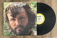 Photo showing the front cover of the 'Me And Bobby McGee' vinyl album by Kris Kristofferson with vinyl record partly visible.
