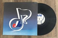 Vinyl record partially pulled from sleeve, showing Expos-themed design on sleeve and baseball-themed label on record.