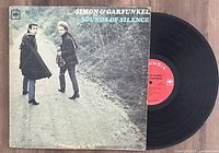 Simon & Garfunkel Sounds of Silence vinyl record LP partially out of its cover on a wooden floor