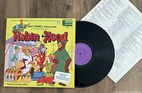 Photo of Walt Disney Robin Hood vinyl LP record alongside illustrated album cover and lyric sheet.