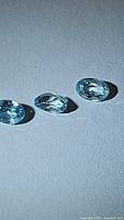 Photo showing three natural sky blue Cambodian zircon gemstones in oval cut with good clarity and bright color.