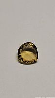 Top view of the pear-shaped faceted champagne citrine gemstone on a light background