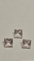 Three square rose quartz gemstones, 5mm each, laid on neutral background showing clarity and faceting