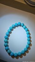 Natural turquoise chunky bead stretchy bracelet arranged in a circle, showing full bead range and blue coloration under a single light source.