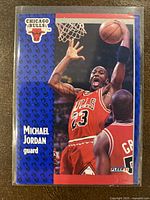 Front of 1991-92 Fleer Michael Jordan basketball card showing Jordan in Chicago Bulls red uniform dunking, with team logo and player info on front left side.