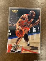 Front of 1996-97 Fleer Michael Jordan basketball trading card showing Jordan in red Chicago Bulls uniform dribbling basketball, card number 13.