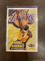 Front of 1997-98 NBA Hoops Kobe Bryant Basketball Card #75 showing Kobe dunking in Lakers uniform.