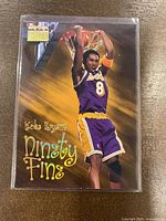 Front of 1998-99 Skybox Premium Kobe Bryant Ninety Fine basketball card showing Kobe in LA Lakers uniform dunking.