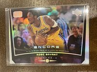 Front view of the 1998-99 Upper Deck Encore Kobe Bryant Basketball Card #39 showing Kobe Bryant dribbling in Lakers yellow jersey with holographic foiling and print line defect.