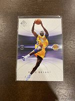 Front of Kobe Bryant basketball card showing action shot in Lakers uniform with SP Authentic branding and card number 38.