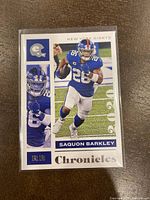 Front of the 2020 Panini Chronicles Saquon Barkley football card showing player action image, name, position and team information.