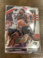 Front view of 2020 Panini Prizm Anthony Edwards rookie card showing player in action with basketball and team logos.