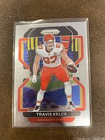Front of 2021 Panini Prizm Travis Kelce football card showing player image and card design.