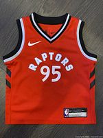 Front view of red Nike Toronto Raptors toddler basketball jersey showing 'Raptors' and number '95' with Nike logo and NBA tag on the lower hem