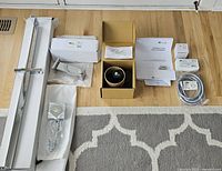 All included components laid out on the floor showing faucet, shower slide bar, shower head, accessories, hose, and installation instructions.
