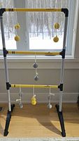 Sportcraft Bungee Ladderball game set fully assembled indoors showing the frame with bungee ladder bars and attached balls.