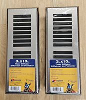 Photo showing two new floor vent covers in original packaging with labels specifying 3 x 10 inch size and satin nickel finish.