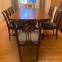 Full set showing table, 6 chairs and 3 leaves leaned in background