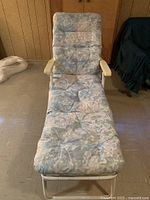 Front view of lawn chair showing full floral cushioned pad covering seat, back and leg rest