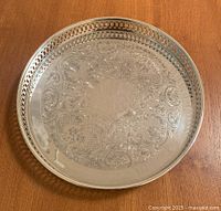 Top view of the silver plated round tray showing detailed engraved floral and scroll work within a pierced rim