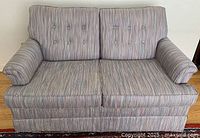 Gray striped two-seat Norwalk sofa in good condition needing cleaning, shown closed.