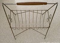 Top and side view of rectangular metal magazine rack with wooden handle and curved metal dividers