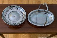 Two vintage silver plated trays: oval tray with handle and round tray with pierced edges and raised support base.