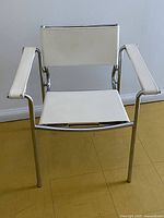 Front view showing chair seat, backrest and armrests with white upholstery and chrome frame.