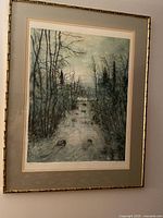 Framed lithograph artwork depicting a water stream with bare trees in a muted color palette.