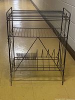 Full frontal view of vintage metal wire LP record rack with three storage levels and dividers at the bottom for records
