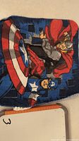 Close-up photo of cloth with printed Captain America and Thor