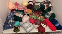 Full view of mixed yarn balls in various colors and sizes spread out on white surface