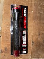 Front view of one black and red EverBright LED flashlight in packaging, showing branding and features