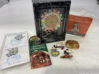 Overview photo showing all Disney pins, including limited edition box set, 102 Dalmatians pin in packaging, and various Mickey Mouse pins with colorful designs.