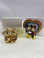 Front view of two Disney Mickey figurines with their original white foam packaging and Harmony Kingdom information leaflet.