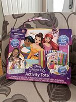 Front of the packaging showing Disney Princess theme with three princess characters and included contents.