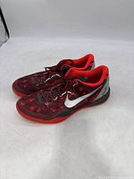 Pair of red and black Nike Kobe 8 sneakers angled to show side and upper design.