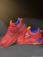 Side view of the men's Puma red sneakers showing side profile, colors, and Puma branding.