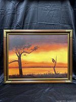 Full view of the framed painting showing the entire canvas of a sunset landscape with tree and bird.